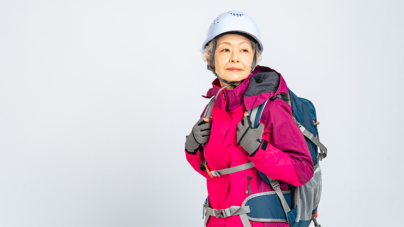 防災ヘルメットをかぶりリュックを背負ったシニア女性
