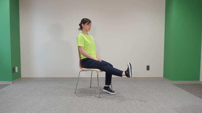 椅子の背もたれから背中を離す。その姿勢のまま、片方の膝をゆっくりと伸ばす女性