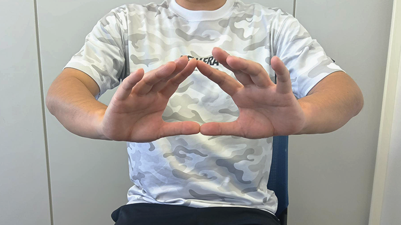 膝を90度に曲げた状態で座る男性