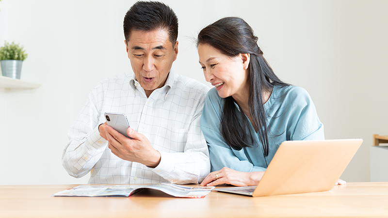 スマートフォンで外出先のトイレや経路を事前に調べるシニア夫婦