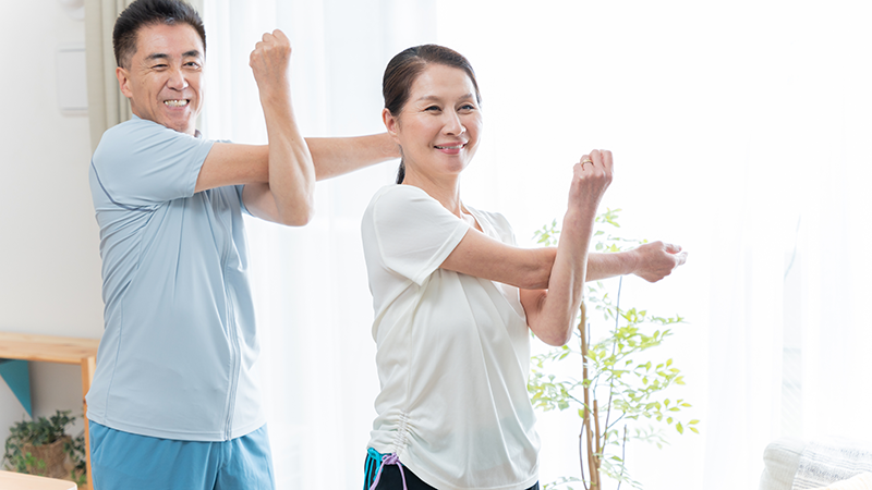 腕のストレッチをするシニア夫婦