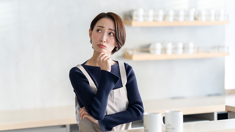 キッチンで「何だっけ?」と考え込む50代女性