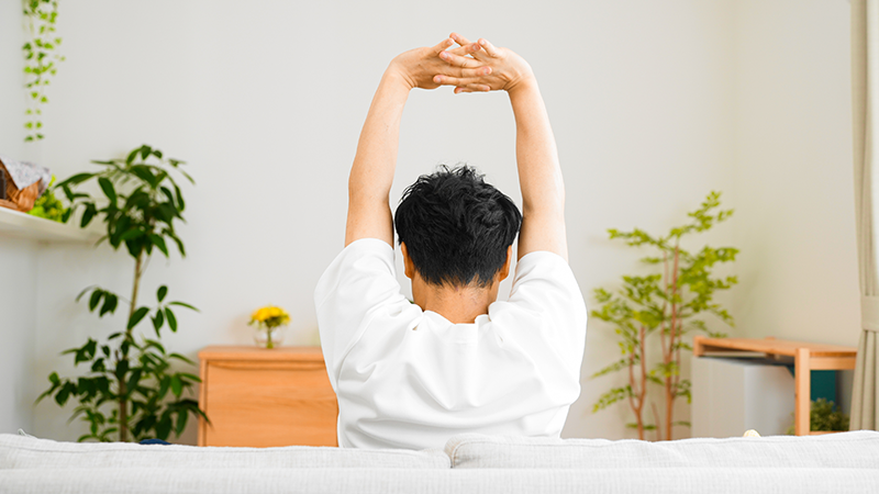 背筋を伸ばす男性