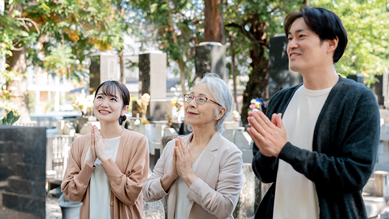 家族でお墓参りをする様子